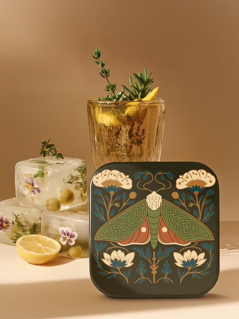 A set of four square hardboard coasters with smoothly rounded corners and a protective high-gloss finish. Each coaster features a unique, highly detailed Art Nouveau style illustration of a moth centered against a dark, botanical background. The intricate artwork uses a rich, moody color palette of deep forest greens, ochre, muted olive, crimson, and black, evoking a vintage, scholarly feel. These decorative drinkware accessories are designed for coffee table and bar cart use.